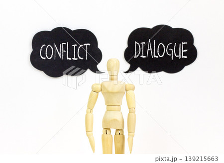 Dialogue instead conflict symbol. Concept words Dialogue and Conflict on beautiful black speech bubbles. Beautiful white background. Businessman model. Social dialogue conflict concept. Copy space. 139215663