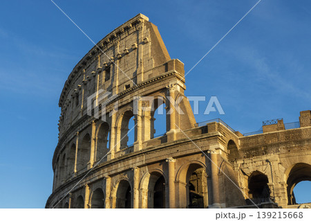 Famous Coliseum in Rome. Colosseum, or Coliseum. Sunset at huge Roman amphitheatre, Rome, Italy, Europe. Famous touristic place in the world and Europe. Beautiful blue sky background. 139215668