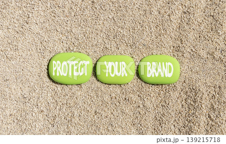 Protect your brand words symbol. Concept words Protect your brand on beautiful green stones. Beautiful sand beach background. Business and protect your brand concept. Copy space. 139215718