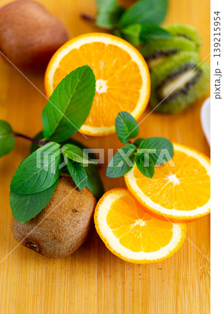 fresh orange slices with kiwi on wooden board background 139215954