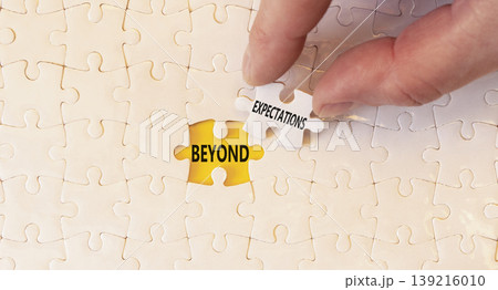 Beyond expectations words symbol. Concept words Beyond expectations on beautiful white puzzles. Beautiful yellow background. Businessman hand. Business Beyond expectations words concept. Copy space. Beyond expectations words symbol. Concept words Beyond expectations on beautiful white puzzles. Beautiful yellow background. Businessman hand. Business Beyond expectations words concept. Copy space. 139216010