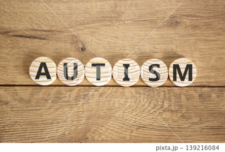 Autism medical symbol. Concept word Autism on beautiful wooden circles. Beautiful wooden background. Business autism medical concept. Copy space. Autism medical symbol. Concept word Autism on beautiful wooden circles. Beautiful wooden background. Business autism medical concept. Copy space. 139216084