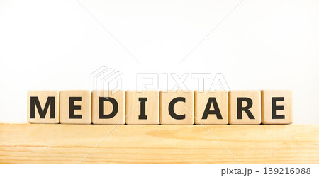 Medicare word symbol. Concept word Medicare on beautiful wooden blocks on wooden beam. Beautiful white background. Medical support help medicare word concept. Copy space. 139216088