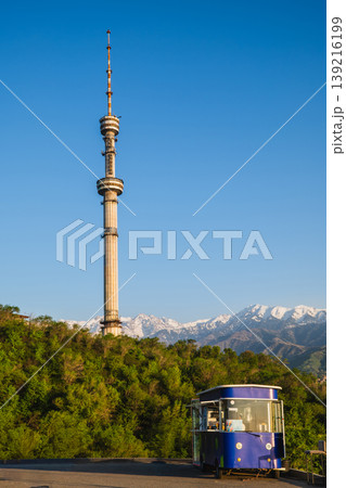 Kok Tobe tower with blue ice cream kiosk on hill road with Tian Shan mountains in Almaty Kazakhstan 139216199