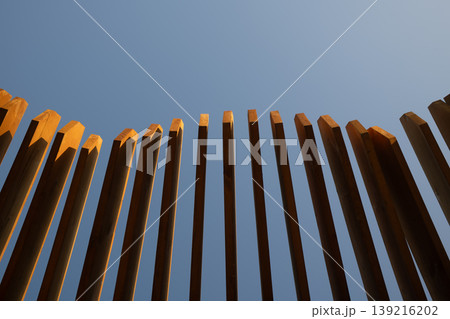 Curved wooden pergola or trellis slats abstract geometric pattern with blue sky background Curved wooden pergola or trellis slats abstract geometric pattern with blue sky background 139216202