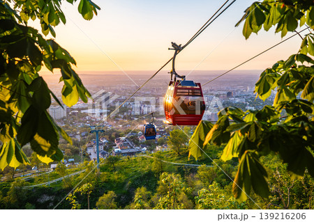 Cable car gondola over Almaty city at colorful sunset with cityscape Cable car gondola over Almaty city at colorful sunset with cityscape 139216206