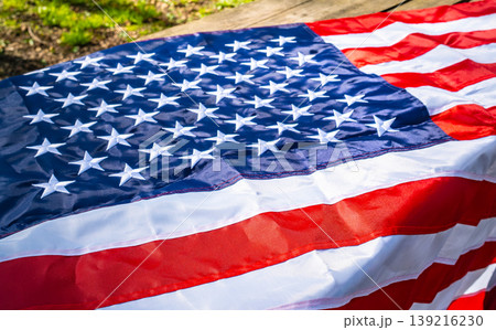 American flag draped on rustic wooden plank surface American flag draped on rustic wooden plank surface 139216230