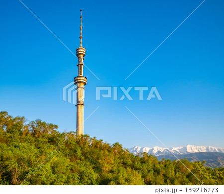 Kok Tobe TV tower landmark against clear blue sky with snow capped Tian Shan mountains in Almaty Kazakhstan Kok Tobe TV tower landmark against clear blue sky with snow capped Tian Shan mountains in Almaty Kazakhstan 139216273