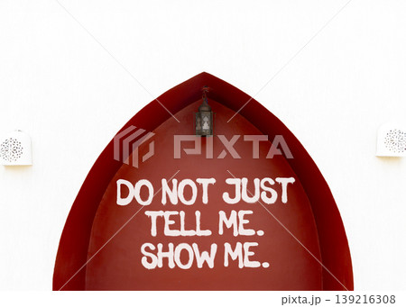 Tell or show symbol. Concept words Do not just tell me, show me on beautiful red wall. Beautiful white wall background. Business tell or show concept. Copy space. 139216308