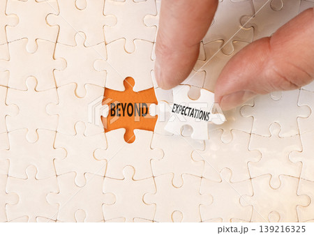 Beyond expectations words symbol. Concept words Beyond expectations on beautiful white puzzles. Beautiful orange background. Businessman hand. Business Beyond expectations words concept. Copy space. Beyond expectations words symbol. Concept words Beyond expectations on beautiful white puzzles. Beautiful orange background. Businessman hand. Business Beyond expectations words concept. Copy space. 139216325