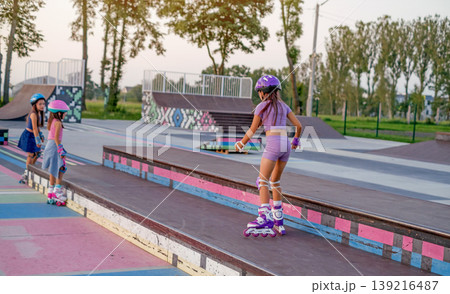 A girl rides roller skates on a ramp before jumping. A skate park for professional sports training. A girl rides roller skates on a ramp before jumping. A skate park for professional sports training. 139216487