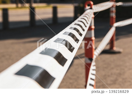 Caution tape and orange traffic cones marking a restricted area outdoors 139216829