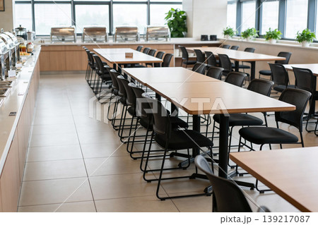 Modern office cafeteria with buffet serving stations and empty dining tables and chairs Modern office cafeteria with buffet serving stations and empty dining tables and chairs 139217087