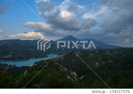 Breathtaking view of the tranquil lake and majestic mountains under a dramatic sky at dusk in a remote natural landscape 139217370
