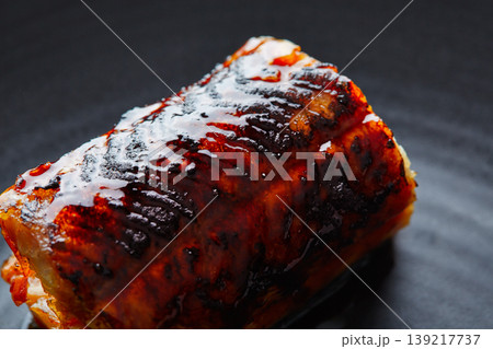 Grilled smoked eel on black plate Grilled smoked eel on black plate 139217737
