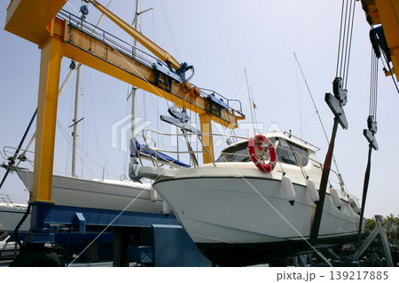 Dock crane elevating a fishing boat 139217885