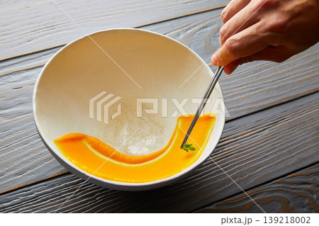 creamy carrot cream painted on white bowl 139218002