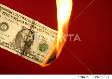 Dollar note burning in fire over red 139218554