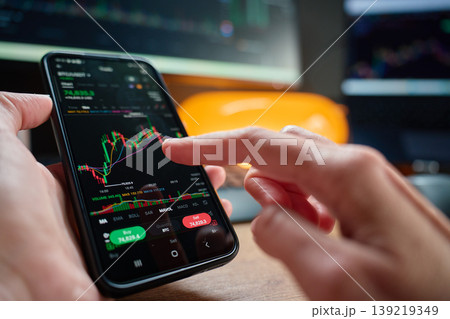 Person analyzing market chart on smartphone Person analyzing market chart on smartphone 139219349