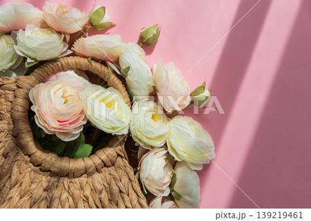 Straw Handbag with Ranunculus Flowers on Pink Background 139219461