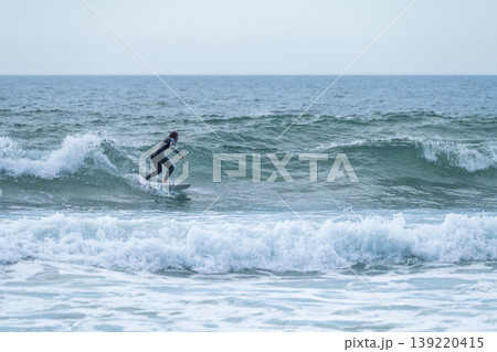 Surfer girl riding a wave 139220415