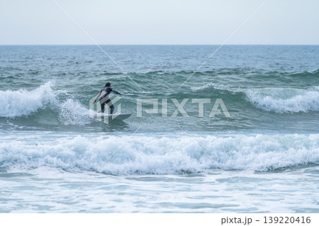 Surfer girl riding a wave 139220416