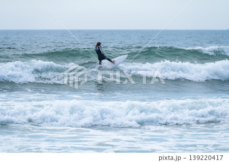 Surfer girl riding a wave 139220417