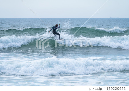 Surfer girl riding a wave Surfer girl riding a wave 139220421