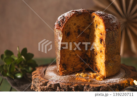 Half-Sliced Panettone Cake with Chocolate and Festive Greenery Half-Sliced Panettone Cake with Chocolate and Festive Greenery 139220711