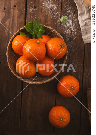 Fresh Tangerines in a Woven Basket on a Rustic Wooden Table Fresh Tangerines in a Woven Basket on a Rustic Wooden Table 139220749
