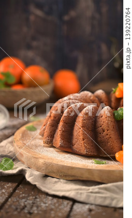Vertical High Angle of a Tangerine Bundt Cake on Rustic Wood Surface Vertical High Angle of a Tangerine Bundt Cake on Rustic Wood Surface 139220764