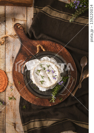 Baked Camembert Cheese with Fresh Rosemary and Purple Flowers on Rustic Wooden Board 139220814