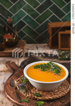 Creamy Pumpkin Soup with Fresh Herbs and Sesame Seeds in a Rustic Kitchen Setting Creamy Pumpkin Soup with Fresh Herbs and Sesame Seeds in a Rustic Kitchen Setting 139220841