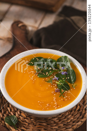 Creamy Butternut Squash Soup Topped with Fresh Spinach and Sesame Seeds 139220844