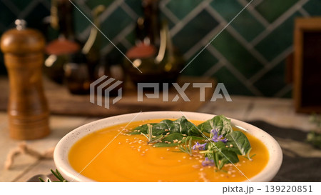 Creamy Butternut Squash Soup Topped with Fresh Spinach and Rosemary in a Rustic Kitchen Setting Creamy Butternut Squash Soup Topped with Fresh Spinach and Rosemary in a Rustic Kitchen Setting 139220851