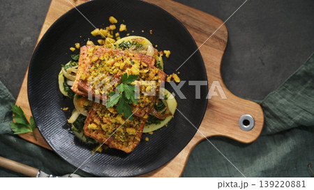 Crispy Breaded Tofu Steaks Served Over Sauteed Spinach and Onions on a Modern Black Plate Crispy Breaded Tofu Steaks Served Over Sauteed Spinach and Onions on a Modern Black Plate 139220881