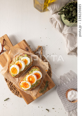 Top View of Avocado Toast with Sliced Boiled Eggs on a Wooden Board Top View of Avocado Toast with Sliced Boiled Eggs on a Wooden Board 139220885