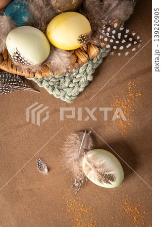 Vertical Flat Lay of Easter Eggs in a Wicker Basket with Feathers and Spices Vertical Flat Lay of Easter Eggs in a Wicker Basket with Feathers and Spices 139220905
