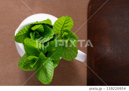 Fresh Mint Sprigs in a White Ceramic Pitcher Top View Fresh Mint Sprigs in a White Ceramic Pitcher Top View 139220954