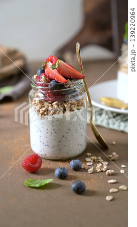 Healthy Berry Chia Pudding Parfait in a Glass Jar with Gold Spoon 139220964