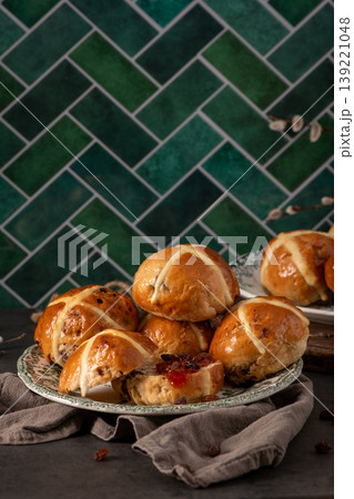 Vertical View of Glazed Hot Cross Buns on Vintage Plates with Green Tile Backdrop 139221048