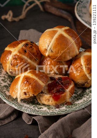 Traditional Easter Hot Cross Buns Stacked on Vintage Plate with Jam and Sultanas Traditional Easter Hot Cross Buns Stacked on Vintage Plate with Jam and Sultanas 139221111