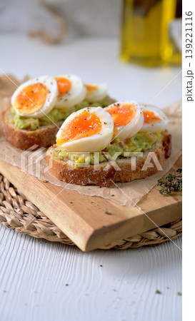 Avocado Toast with Soft Boiled Jammy Eggs on a Wooden Board Avocado Toast with Soft Boiled Jammy Eggs on a Wooden Board 139221116