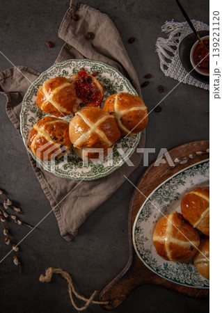 Fresh Homemade Hot Cross Buns with Fruit Jam and Raisins on a Rustic Table Fresh Homemade Hot Cross Buns with Fruit Jam and Raisins on a Rustic Table 139221120