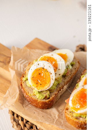 Sourdough Toast with Smashed Avocado and Soft Boiled Egg Slices 139221161