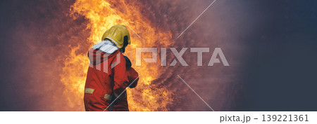 Firefighter fighting smoke flame use fire hose chemical water foam spray engine. Firefighter Rescue training in fire fighting extinguisher. Fireman wear hard hat safety suit uniform for protection 139221361