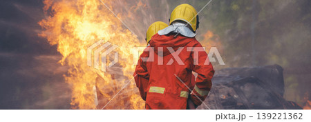 Firefighter fighting smoke flame use fire hose chemical water foam spray engine. Firefighter Rescue training in fire fighting extinguisher. Fireman wear hard hat safety suit uniform for protection Firefighter fighting smoke flame use fire hose chemical water foam spray engine. Firefighter Rescue training in fire fighting extinguisher. Fireman wear hard hat safety suit uniform for protection 139221362