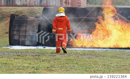 Firefighter Rescue training in fire fighting extinguisher. Firefighter fighting with flame using fire hose chemical water foam spray engine. Fireman wear hard hat, safety suit uniform for protection 139221364