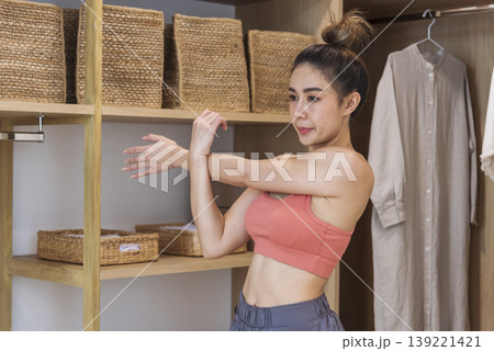 Sport Women home fitness workout exercise in living room healthy lifestyle. Asian Young woman wear wellness sportswear arms stretching firm body workout slim slender. Healthy wellness woman concept Sport Women home fitness workout exercise in living room healthy lifestyle. Asian Young woman wear wellness sportswear arms stretching firm body workout slim slender. Healthy wellness woman concept 139221421