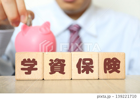 学資保険。貯金箱と積立投資イメージ。教育費と資産形成。木製ブロック文字 学資保険。貯金箱と積立投資イメージ。教育費と資産形成。木製ブロック文字 139221710